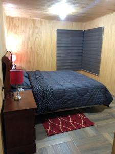 a bed in a room with a desk and a bed sidx sidx sidx at Cabaña Recinto Valle Las Trancas in Recinto