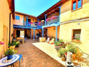 eine Außenterrasse mit Tischen, Stühlen und Pflanzen in der Unterkunft Albergue Villares de Orbigo in Villares de Órbigo