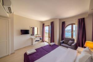 una camera d'albergo con un letto grande e una finestra di Riva Bodrum Resort- Adult Only +16 a Gümbet