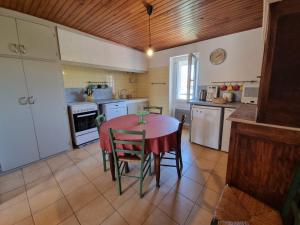a kitchen with a table and chairs in a room at appartement 2 chambres in Maureillas