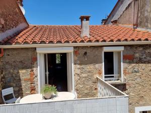 an old stone house with a tile roof at appartement 2 chambres in Maureillas