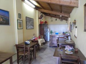 una cucina e una sala da pranzo con tavoli e sedie in legno di Residence il Colle a Collestrada