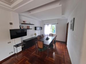 a dining room with a table and chairs and a television at Casa céntrica. A Coruña a 200m de la playa Riazor in A Coruña