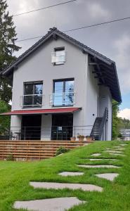 a house on top of a green hill with stepping stones at Apartmány Aktiv Lipno in Lipno nad Vltavou