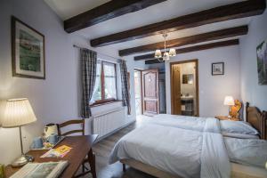 1 dormitorio con cama, mesa y escritorio en Chambres d'Hôtes Chez Mado Ottrott en Ottrott