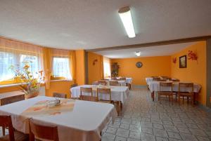 a dining room with white tables and chairs and yellow walls at Willa Rysówka in Poronin