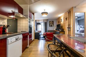 a kitchen with a counter and chairs in a room at APPARTEMENT CENTRE VILLE PARKING COUVERT WIFI BALCON in Cauterets
