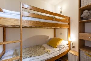 a bedroom with two bunk beds with a yellow pillow at APPARTEMENT CENTRE VILLE PARKING COUVERT WIFI BALCON in Cauterets