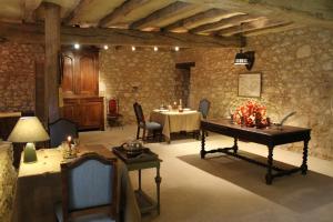 a room with a table and chairs in a room with a stone wall at Chateau de Forges in Concremiers