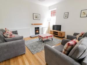 a living room with two couches and a fireplace at Clocktower - Culzean Castle in Maybole