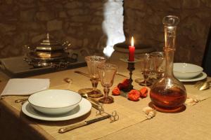 una mesa con una vela y algunos platos y vasos en Chateau de Forges en Concremiers
