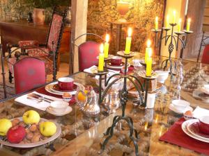 a table with candles and plates of food on it at Chateau de Forges in Concremiers +22 photos