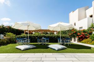 a patio with tables and chairs and umbrellas at Ikaros Studios & Apartments in Naxos Chora