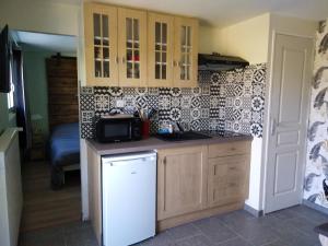 a kitchen with a white refrigerator and a microwave at Au petit gravelot in Aulx-lès-Cromary