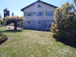 a large white house with a clock tower in a yard at Au petit gravelot in Aulx-lès-Cromary