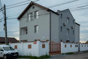 a white house with a car parked in front of it at Solomon Apartments Ap 4 in Sângeorgiu de Mureș