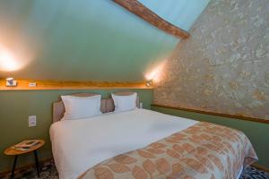 a bed in a room with a white bed at Gîte de la Besnardière in Mareuil-sur-Cher