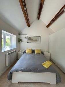 a bedroom with a large bed with yellow pillows at The Cottage at No. 3 in West Lavington