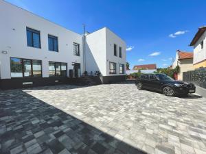 a black car parked in front of a white building at Majestic Boutique Hotel ADULT ONLY in Baile Felix