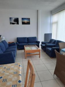 a living room with blue couches and a coffee table at Appartement moderne de 94 m² 2 ch. sur la digue in Nieuwpoort