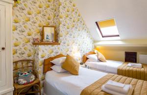 a hotel room with two beds and a mirror at Broadlands Guest House in Stratford-upon-Avon