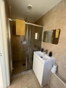 a bathroom with a shower and a white sink at The Cottage at No. 3 in West Lavington