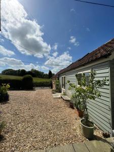 a house with a gravel driveway next to a building at The Cottage at No. 3 in West Lavington