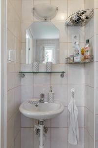 ein Bad mit einem Waschbecken und einem Spiegel in der Unterkunft VirágLak in Gárdony