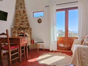 a living room with a desk and a fireplace at Casa dos Pinheiros in Praia da Arrifana