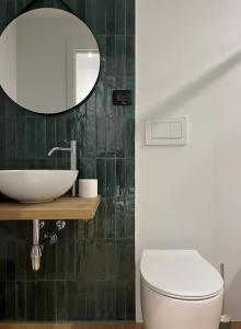 a bathroom with a sink and a toilet and a mirror at Casa Floris in San Benedetto del Tronto