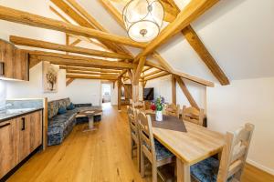 a dining room and living room with wooden ceilings at Ferienhof Domäne Groschwitz in Rudolstadt