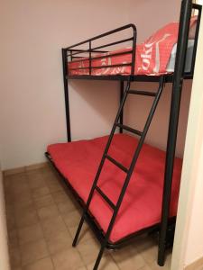 2 literas en una habitación con sábana roja en studio vue sur mer, en Le Barcarès
