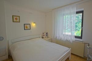 una camera da letto bianca con un letto e una finestra di The Village Rest - Brezje Gorenjska a Brezje