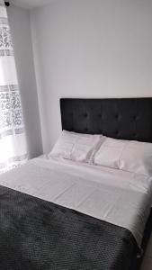 un letto con testiera nera in una camera da letto di GUADUALES DEL CAFE 410B- VIVIENDA TURISTICA a Montenegro