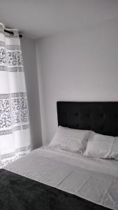 un letto con testiera nera in una camera da letto di GUADUALES DEL CAFE 410B- VIVIENDA TURISTICA a Montenegro Altre 39 foto