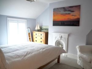 a bedroom with a bed and a window and a dresser at The Seaview Snug in Whitstable