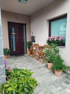 a patio with a wooden table and potted plants at Apartma Mango in Bled