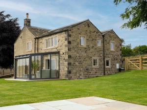 a brick house with large windows and a yard at Woodview Farm in Huddersfield