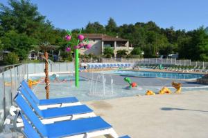 uma piscina com cadeiras azuis e um parque aquático em La Maison Roussel em Rosières