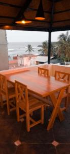 a wooden table and chairs with a view of the ocean at Catch A Wave in Mahabalipuram
