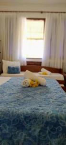 una camera d'albergo con due letti e un asciugamano sul letto di Pousada Luz do Porto a Porto De Galinhas