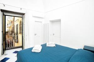 a bedroom with a blue bed with two towels on it at La Finestra sul Corso in Amalfi