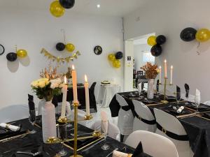 un comedor con una mesa con globos negros y amarillos en Semeni Asante Guesthouse en Johannesburgo