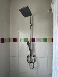 a shower with a shower head in a bathroom at Northwood Gardens in Accra