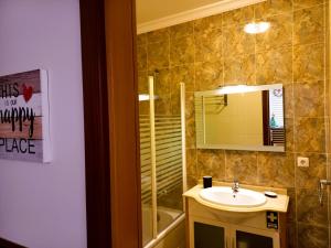 uma casa de banho com um lavatório, um espelho e uma banheira em Nelo's Cousy place em Portimão