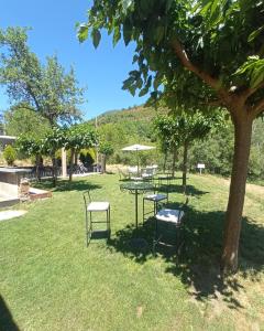 a group of chairs and tables in a park at Hotel La Casa del Río in Villanova