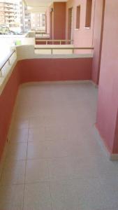 Habitación vacía con suelo de baldosa y paredes de color rosa. en Apart Rubi II Vv, en La Manga del Mar Menor