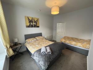 a bedroom with two beds with shoes on them at Petteril House - Ground Floor in Carlisle