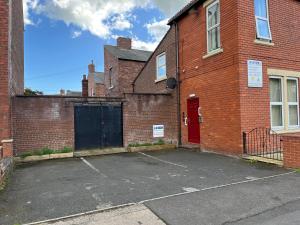 an empty parking lot in front of a brick building at Petteril House - Ground Floor in Carlisle