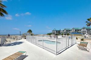 une clôture avec des chaises et une piscine dans l'établissement Gulf Shores Plantation Unit 2319, à Gulf Highlands